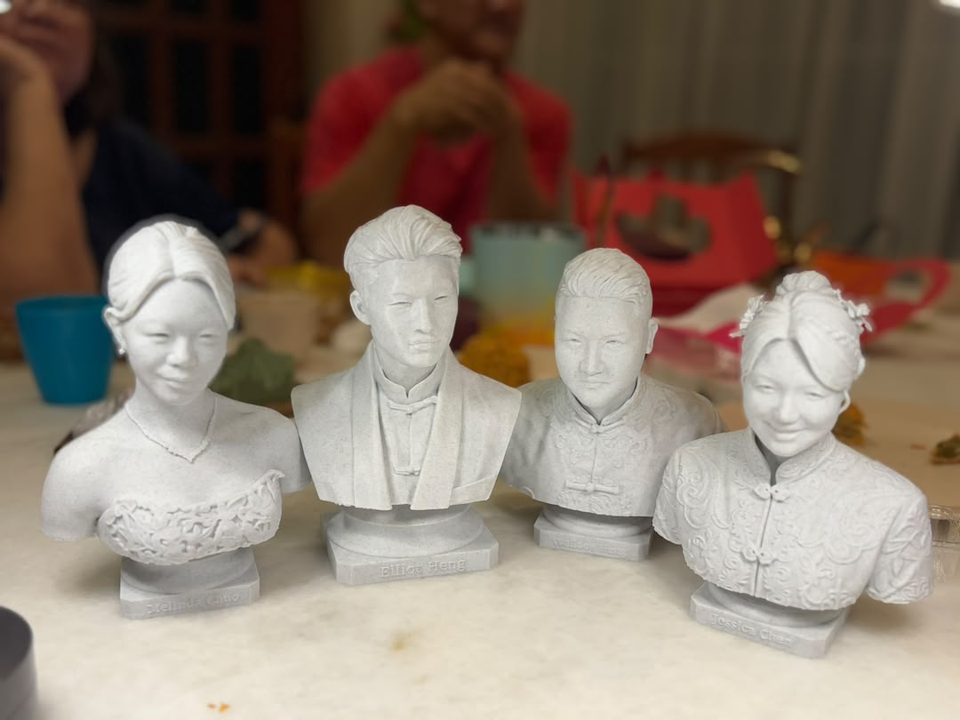 Four marble statue caricatures lined up on a table